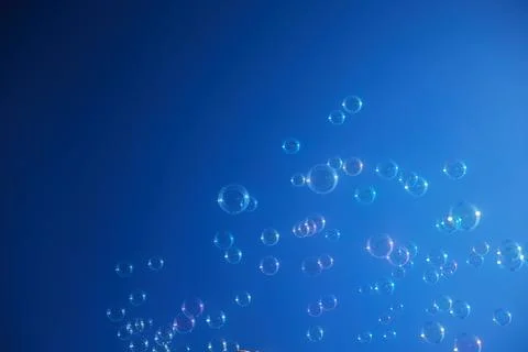 Floating Bubbles Against Blue Sky Foto stock