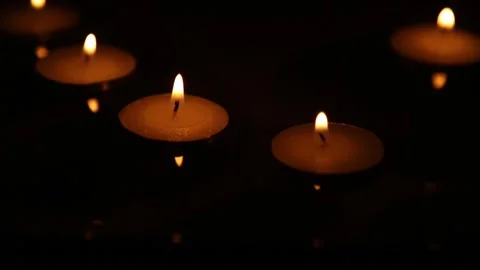 Floating candle flames on dark reflective surface Stock Footage 323219443