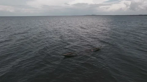 Floating canoe, abandoned and half-filled with water, on lake Victoria Stock Footage 230080160