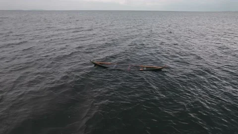Floating canoe, abandoned and half-filled with water, on lake Victoria Stock Footage 230080212