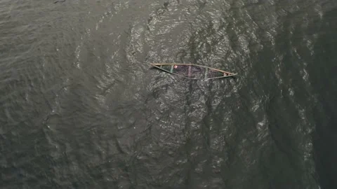 Floating canoe, abandoned and half-filled with water, on lake Victoria Stock Footage 230080296