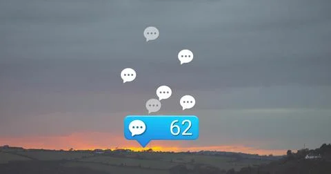 Floating chat bubble icons drifting over fields at sunset, with blue Stock Photos