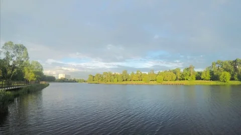 Floating clouds over summer park with a lake timelapse Stock Footage 77285369