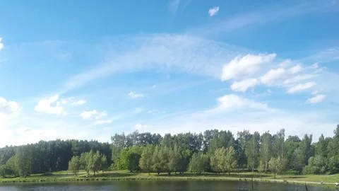 Floating clouds over summer park with lake timelapse Stock Footage 77285413
