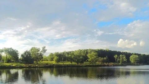 Floating clouds over a summer park with pond timelapse 스톡 동영상 77285425