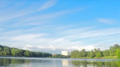 Floating clouds over a summer park with a pond timelapse 스톡 동영상 77285492