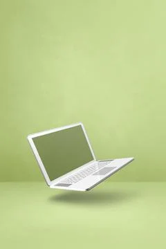 Floating computer laptop isolated on green. Vertical background Illustrazione stock