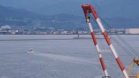 Floating crane equipment over calm ocean waters with distant coastline. 動画素材 345426730