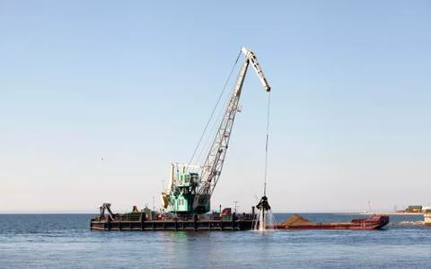 The floating crane loads the barge Stock Photos