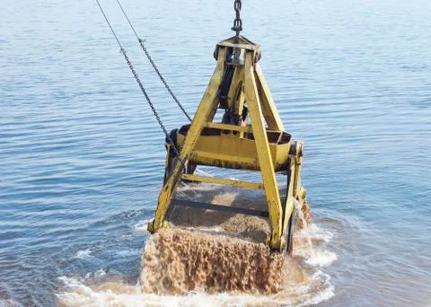 Floating crane scoops soil Stock Photos