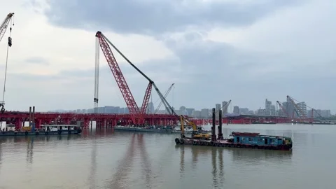 Floating cranes and bridge construction on Qiantang River in Hangzhou under Видео 335278473
