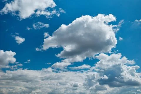 Floating cumulus clouds in the blue sky Stock Photos