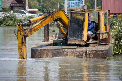 A floating dredger is dredging the bottom of the pond, Thailand Stock Photos