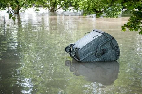 Floating dumpster in flood Stock Photos