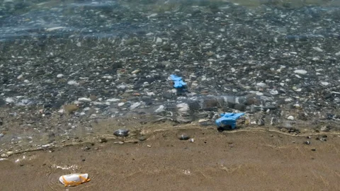 Floating ffp2 protective mask and plastic gloves on sea water,covid pollution Video stock 137759702