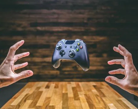Floating Gaming Controller Over Table Stock Photos