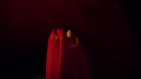 Floating Ghost Shaped Jack O Lantern Against Dark Tunnel Background With Red Lig Stock Footage 337106695
