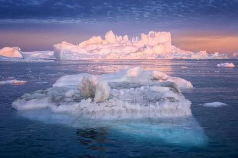 Floating glaciers in the rays of the setting sun at polar night Stock Photos