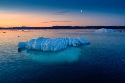 Floating glaciers in the rays of the setting sun at polar night with Moon Stock Photos