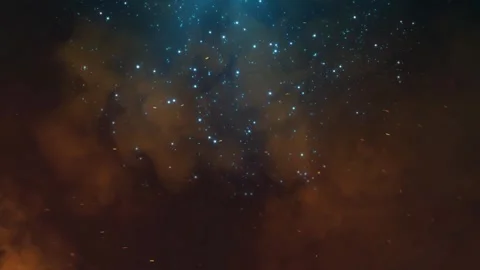 Floating glowing particles rising in dark smoke with blue light flare in a Stock Footage 338439596
