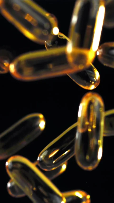 Floating golden capsules radiate elegance in soft luminous environment Filmed on Stock Footage 335396703