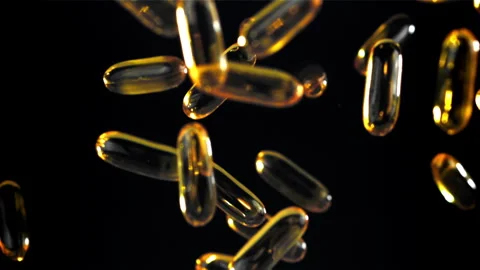 Floating golden capsules radiate elegance in soft luminous environment Filmed on Stock Footage 335424660