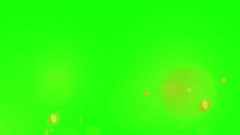 Floating golden particles ascending against a vibrant green screen background Видео 338992662