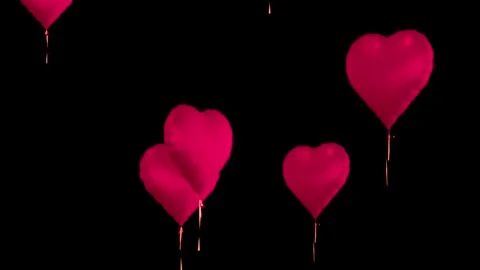 Floating heart shaped balloons ascend against dark empty background Stock Footage 327594889