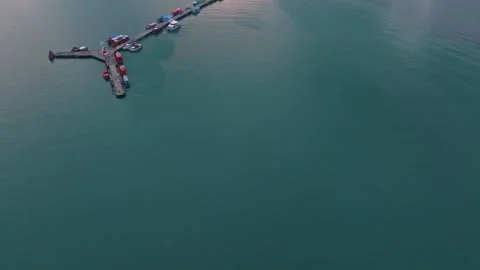 Floating homes and vessels drift in blue waters off Bang Bao, Thailand Stock Footage 310055124