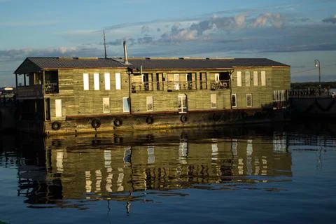 Floating house reflected in the river water on a sunny day Stock Photos