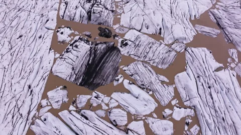 Floating ice chunks with dark streaks in silty glacier water Stock Footage 340263195