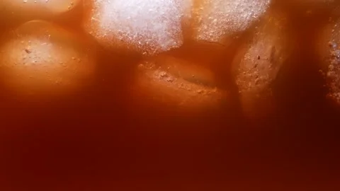 Floating ice cubes in coffee with milk close up. An invigorating, refreshing Video stock 152215165