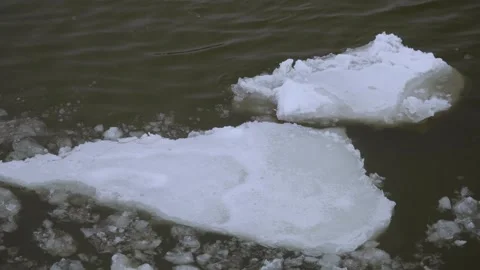Floating Ice Floes and Broken River Ice Drifting on Dark Winter Water Surface. Video stock 333033128