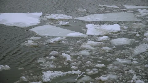 Floating Ice Floes and Broken River Ice Drifting on Dark Winter Water Surface. 動画素材 333033207