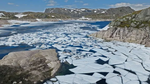 Floating ice fragments covering mountain lake at Hardangervidda National Park. Stock Footage 328130893