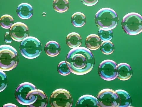 Floating iridescent soap bubbles against a vibrant green background Stock Footage 317888200
