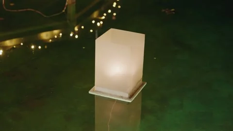 Floating lantern glowing on calm night water Stock Footage 321453352