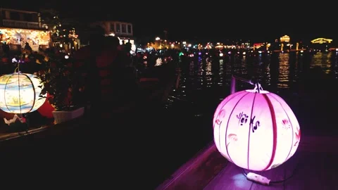 Floating lanterns illuminate lively night at riverside festival in Hoi An Stock Footage 310425546