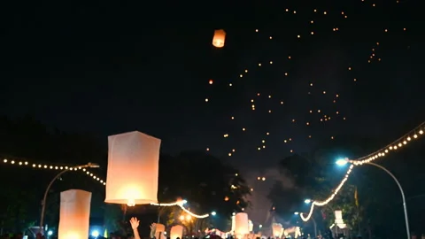 Floating lanterns in the night sky. Launching Sky Lantern. Yee Peng Festival, Lo Stock Footage 153858665