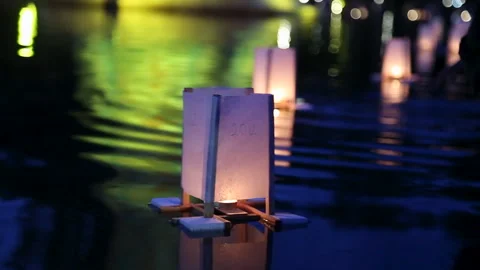 Floating lanterns on water during Obon festival night remembrance ceremony in Stock Footage 331616574