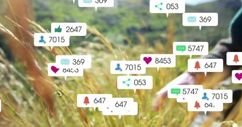 Floating notification bubbles hovering over sunlit meadow, forearm in dark Stock Photos
