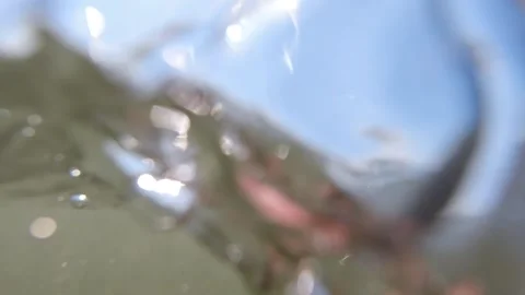 Floating on Ocean Surface with Waves Gently Rolling Over Camera Lens with Stock Footage 243340194