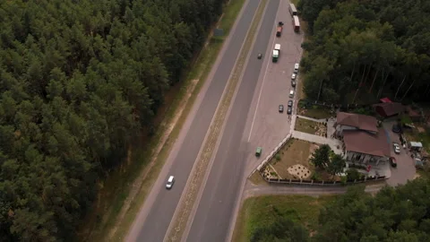 Floating over a long stretch of highway in the middle of a lush green forest.  Stock Footage 169502288