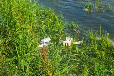 Floating plastic  in the small river. Plastic pollution Stock Photos
