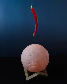 Floating red chilli pepper over the moon Stock Photos