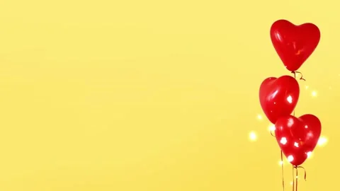 Floating red heart shaped balloons with glowing fairy lights against a bright Vídeo Stock 338992696