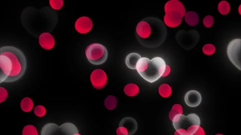 Floating red petals and glowing transparent heart shapes rising against dark Stock Footage 345105369