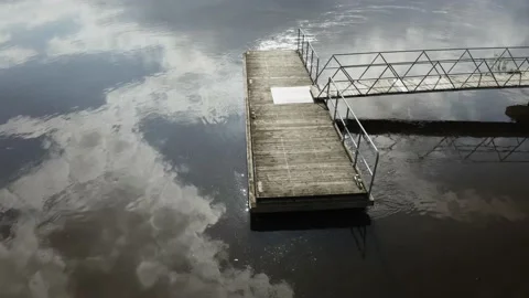 Floating river dock with sun reflection Stockbeeldmateriaal 154675542