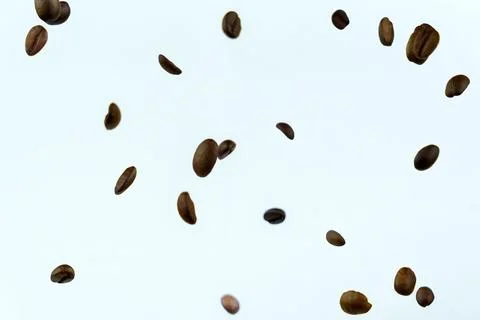 Floating roasted coffee beans on light background Stock Photos