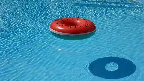 Floating rubber ring, beach ball in water pool top view of crystal clean water Video stock 98835560